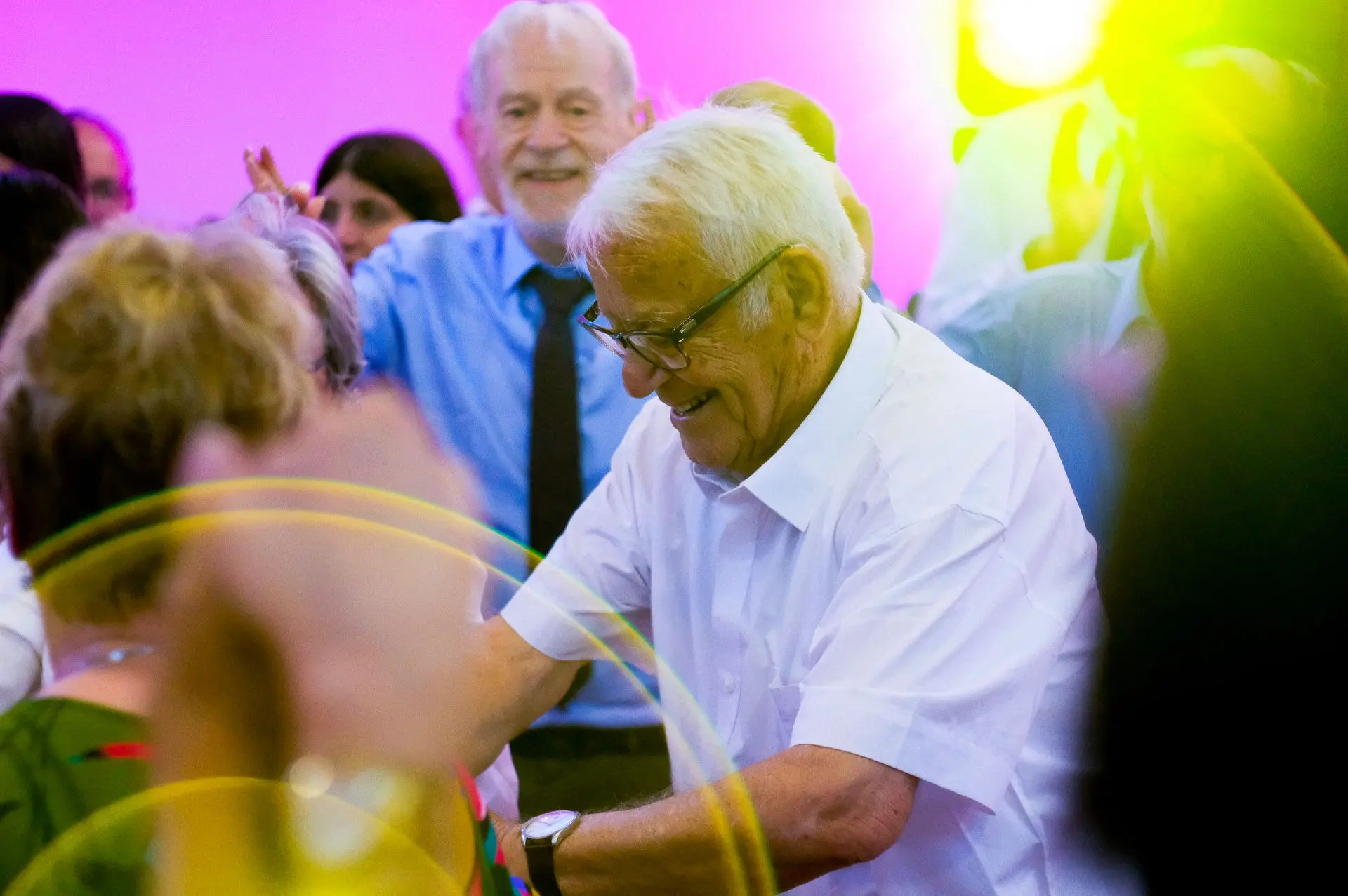 This image captures the beauty of movement beyond age, where experience and joy converge in a dance that transcends time. The elderly dancer becomes the embodiment of celebration, reminding us that weddings are not just about new beginnings but also about honoring the journey that came before. The photograph conveys a sense of nostalgia and resilience, with the interplay of light and shadow adding depth to the emotions on display. In the Barcelona setting, this could also reflect the city's deep-rooted traditions of festivity, where dance is a universal language of connection and vitality.